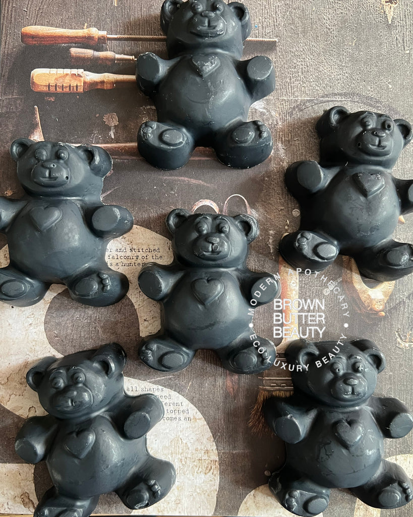Black Teddy bear-shaped soaps on a wooden surface with 'Brown Butter Beauty' branding. Smells like cedarwood
