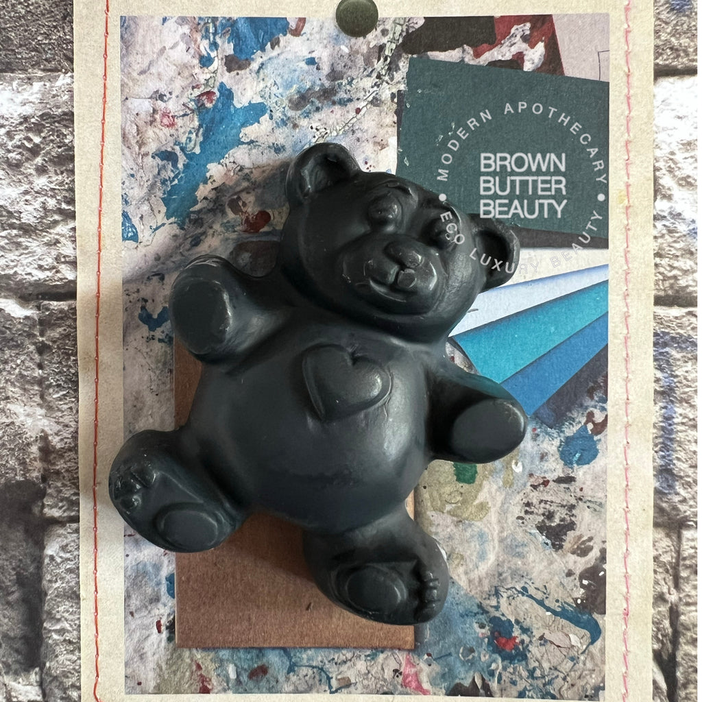 Black Teddy bear-shaped soap on a textured surface with 'Brown Butter Beauty' branding.